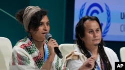 Aya Khourshid, left, speaks next to Jacob Johns as they participate in a panel on Indigenous perspectives at the COP29 U.N. Climate Summit, Monday, Nov. 11, 2024, in Baku, Azerbaijan.