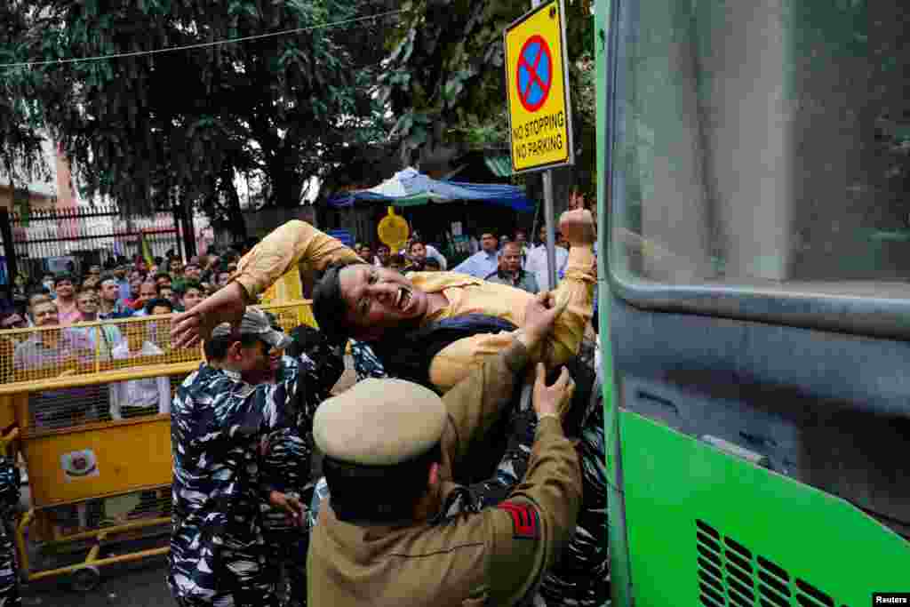 Police detains an activist of the youth wing of India&#39;s main opposition Congress party during a protest demanding the resignation of Home Minister Amit Shah following last week&#39;s clashes in New Delhi.