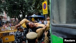 FILE - Police detain an activist of the youth wing of India's main opposition Congress party during a protest demanding the resignation of Home Minister Amit Shah, in New Delhi, March 2, 2020. The protests followed clashes in the city in late February.