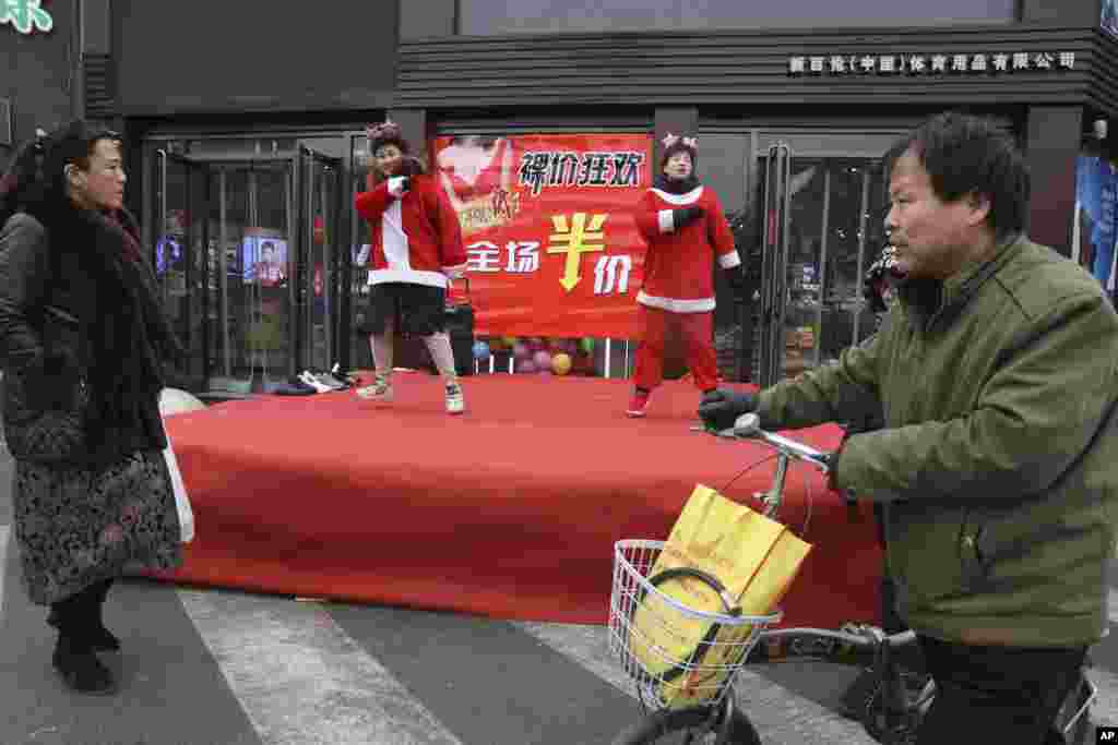 河北省张家口一家服装店进行圣诞促销表演。(2018年12月22日)