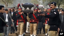 Pakistani police guards carry the coffin of late Punjab governor Salman Taseer during the funeral procession in Lahore on Jan 5, 2011.