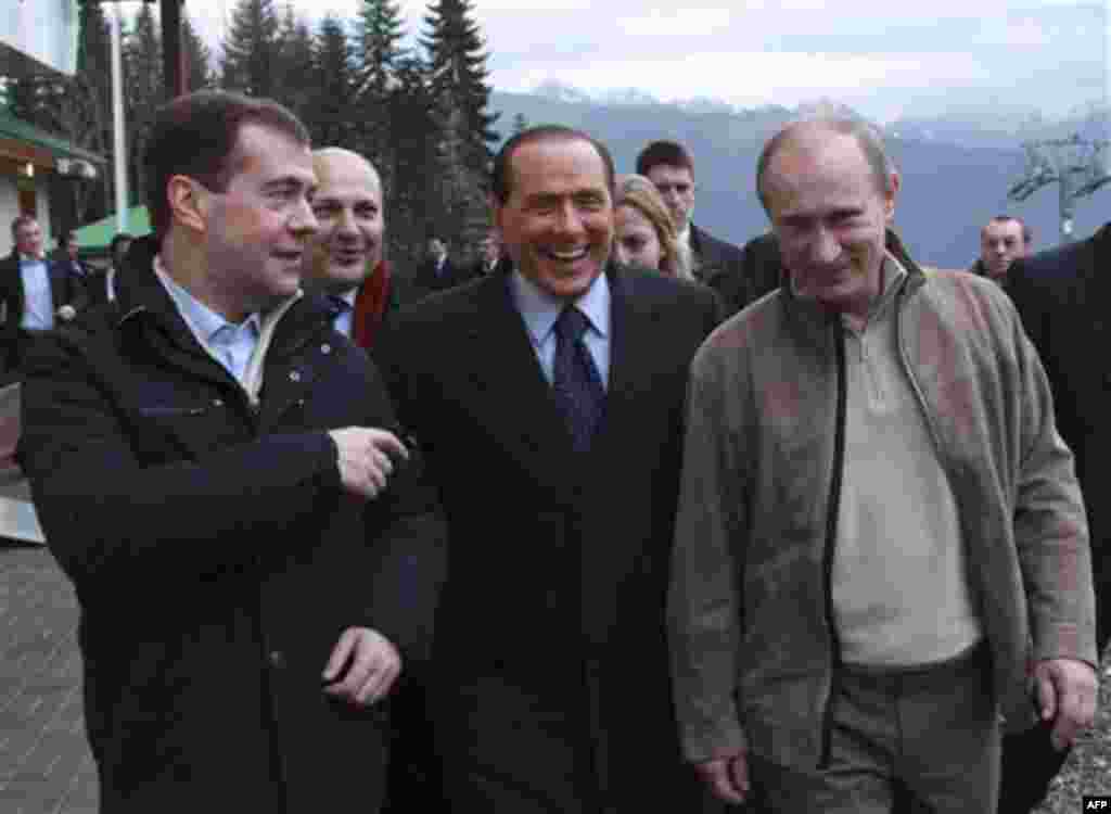 Russian President Dmitry Medvedev, left, Prime Minister Vladimir Putin, right, and Italian Prime Minister Silvio Berlusconi walk in the mountain resort of Krasnaya Polyana near the Black Sea resort of Sochi, southern Russia, Friday, Dec. 3, 2010. Ita