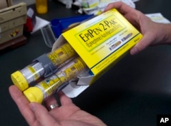 FILE - A pharmacist holds a package of EpiPens epinephrine auto-injector, a Mylan product, in Sacramento, Calif., July 8, 2016. Mylan has a generic version of its emergency allergy treatment and a new competitor has been given FDA approval.