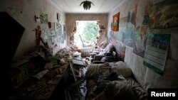 An interior view shows a damaged apartment building following what locals say was recent shelling by Ukrainian forces in the settlement of Maryinka outside Donetsk, July 12, 2014.