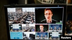 Buronan pemerintah AS Edward Snowden terlihat di layar dalam konferensi jarak jauh dengan Komite HAM Eropa di Strasbourg, 8 April 8, 2014. (Reuters/Vincent Kessler)