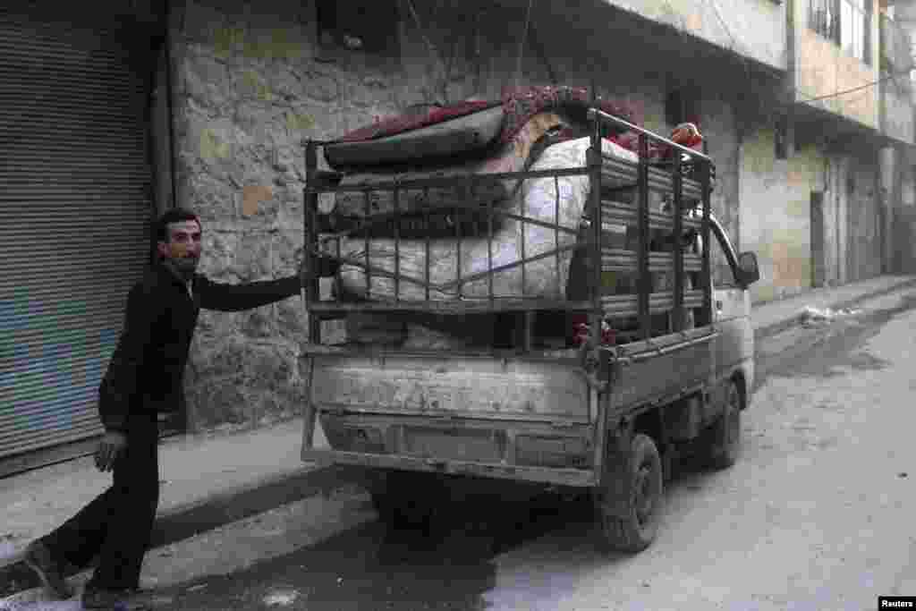 Seorang warga mengepak barang-barangnya menyusul serangan udara yang menurut para aktivis dilakukan oleh pasukan pendukung setia Presiden Suriah Bashar Al-Assad di Al-Maysar, Aleppo (19/1).
