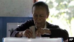 An aged woman casts her ballot at a local polling station on Sunday, Nov. 7, 2010, in Bago, about 90 km northeast of Yangon, Myanmar.