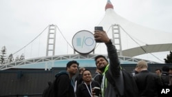 A group of attendees take photos while waiting in line for the keynote address of the Google I/O conference in Mountain View, Calif., May 7, 2019.