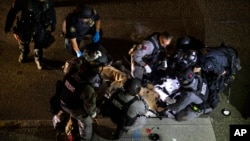 Tim medis kepolisian merawat seorang yang tertembak dalam aksi demonstrasi di Portland, Oregon (29/8). 
