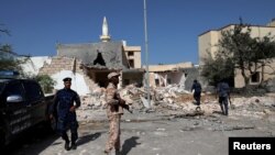 Security members inspect the site of an overnight air strike, which hit a residential district in Tripoli, Libya Oct. 14, 2019. 