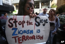 A Lebanese student from the American university in Beirut holds a placard during a protest against the Israeli offensive in Gaza, in Beirut, July 14, 2014.