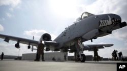 FILE - U.S. military personnel stand beside an A-10C fighter jet at Kandahar Airfield, Afghanistan, Jan. 23, 2018. The U.S. has stepped up airstrikes targeting and destroying Taliban training camps in the northeastern Afghan province of Badakhshan, the U.S. military says.