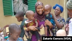 Madame Fadiga de l'Association des Mamans d'Enfants Hydrocéphales de Guinée, entourée d'enfants dans un centre d'hébergement près de Conakry (VOA/Zakaria Camara)