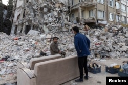 Yasir Bayrakci duduk di sofa yang baru saja mereka pindahkan dari apartemen mereka yang hancur setelah gempa melanda Antakya, Provinsi Hatay, Turki, 20 Februari 2023. (Foto: REUTERS/Eloisa Lopezh)