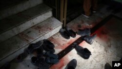 FILE - Blood stains and shoes remain on stairs inside a Sikh house of worship, in the aftermath of an attack on Sikh believers, in Kabul, Afghanistan, March 25, 2020. 