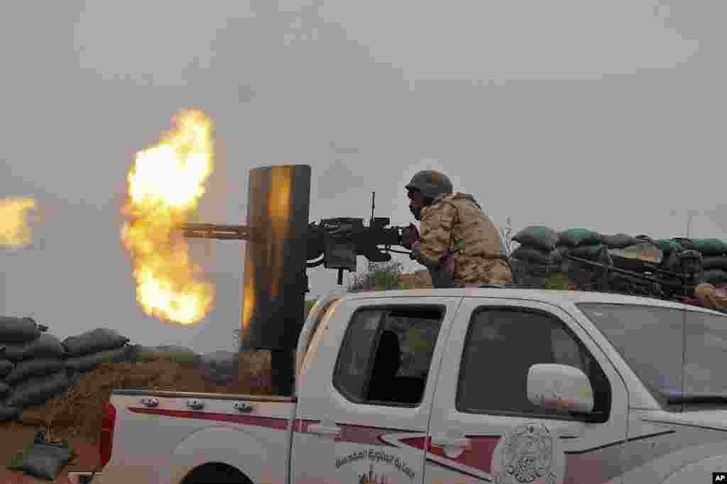 Iraqi security forces and allied Popular Mobilization forces fire towards positions of the Islamic State group in the town of Besher, during a military operation to regain control of the small town, outside the oil-rich city of Kirkuk, 180 miles (290 kilometers) north of Baghdad, April 10, 2016.