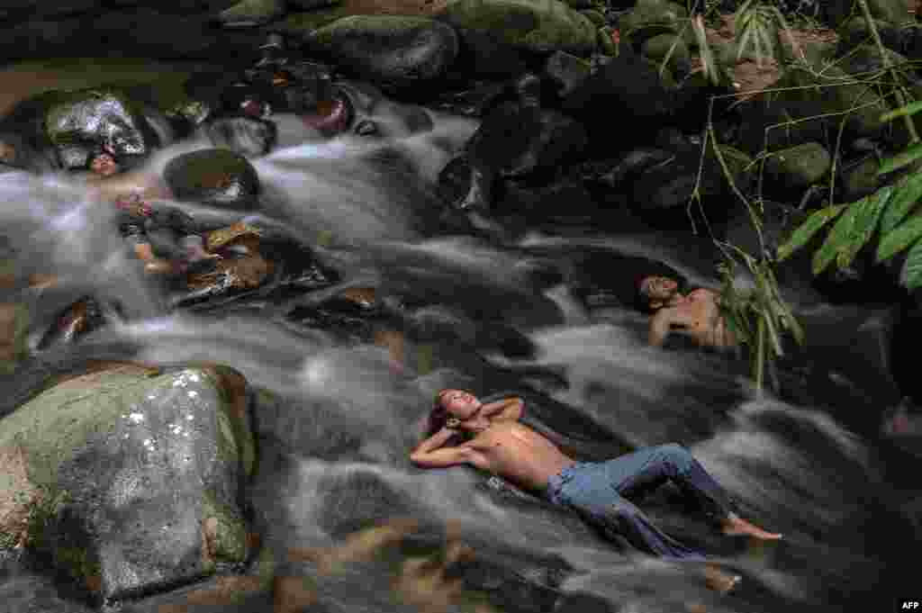 Malaysian youths cool off in a river as schools remain closed due to hazy conditions in Hulu Langat.