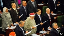 Tunisian parliament members take their oath of office on the Quran during the inaugural session of the newly elected Tunisian parliament in Tunis, Dec. 2, 2014. 