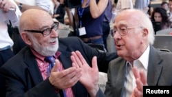 FILE - British physicist Peter Higgs, right, talks with Belgian physicist Francois Englert at CERN news conference, near Geneva, July 4, 2012.