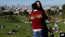 Julie Rajagopal, facing, hugs her 16-year-old foster child from Eritrea after posing for photos at Dolores Park in San Francisco, July 14, 2017. When he landed in March, he was among the last refugee foster children to make it into the U.S. Trump administration travel bans declared to block terrorists also are halting a small, three-decade-old program bringing orphan refugee children to waiting foster families in the United States.