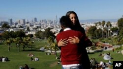 Julie Rajagopal, facing, hugs her 16-year-old foster child from Eritrea after posing for photos at Dolores Park in San Francisco, July 14, 2017. When he landed in March, he was among the last refugee foster children to make it into the U.S. Trump administ