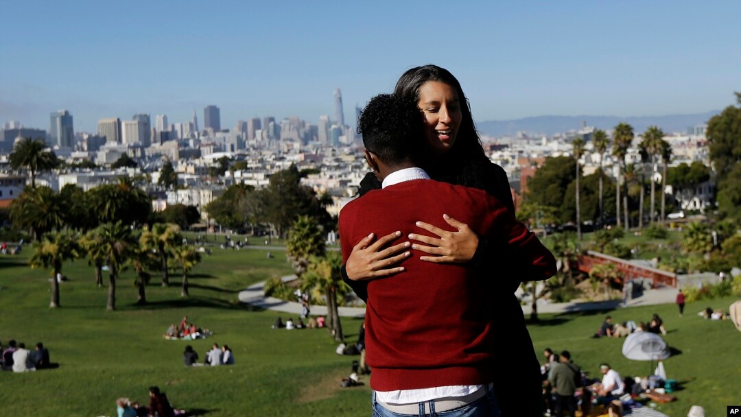 Julie Rajagopal memeluk anak angkatnya yang berumur 16 tahun dan berasal dari Eritrea setelah berfoto di Dolores Park di San Francisco, 14 Juli 2017. Saat datang di bulan Maret, ia termasuk di antara anak-anak angkat dari kalangan pengungsi yang berhasil masuk Amerika. (Foto:dok)
