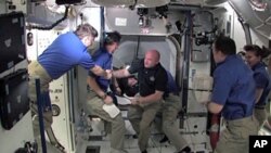 Commander Mark Kelly and the STS-134 crew are welcomed aboard the International Space Station by the Expedition 27 crew, May 18, 2010