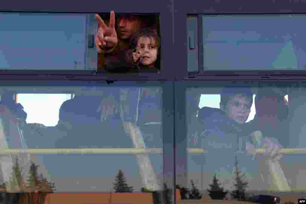 Syrians, who were evacuated from rebel-held neighbourhoods in the embattled city of Aleppo, gesture as they arrive in the opposition-controlled Khan al-Aassal region, west of the city.