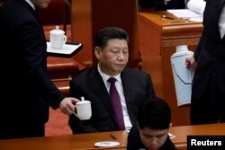 An attendant serves tea for Chinese President Xi Jinping at the opening session of the Chinese People's Political Consultative Conference (CPPCC) at the Great Hall of the People in Beijing, China March 3, 2019.