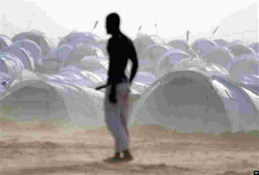 Displaced people play soccer backdropped by their refugee camp at the Tunisia-Libyan border. The camp houses about 5,000 people, trying to handle the large numbers of expatriates crossing the border into Tunisia. (AP/Lefteris Pitarakis)