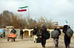 FILE- Afghans return to Afghanistan at the Islam Qala border with Iran, in the western Herat province, Feb. 20, 2019. Taliban have taken control of Islam Qala crossing border, an Afghan official and Iranian media confirmed on July 8, 2021.