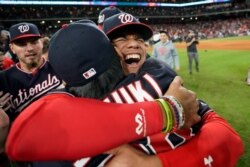 Washington Nationals left fielder Juan Soto, right, hugs catcher Kurt Suzuki after Game 7 of the baseball World Series against the Houston Astros, Oct. 30, 2019, in Houston.