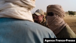  Moussa (not his real name), an interpreter with the United Nations Multidimensional Integrated Stabilization Mission in Mali Long Range Reconnaissance Group, talks to villagers and MINUSMA soldiers during a mission near Menaka, Mali, Oct. 25, 2021.