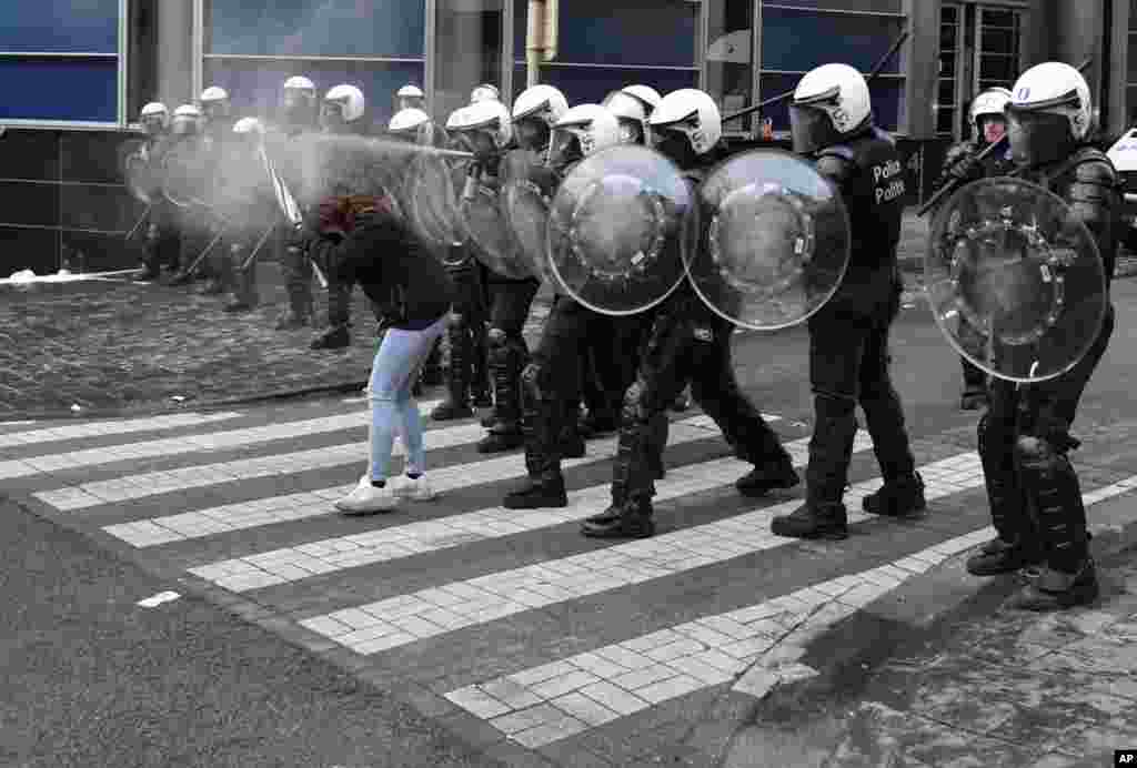 A police officer sprays pepper spray during a protest against coronavirus measures in Brussels, Belgium.