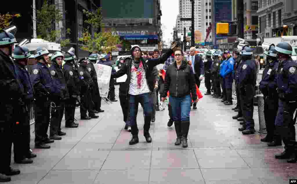 Người biểu tình rời bỏ công viên Zuccotti, đi ngang qua một hàng rào cảnh sát. (AP Photo/John Minchillo)