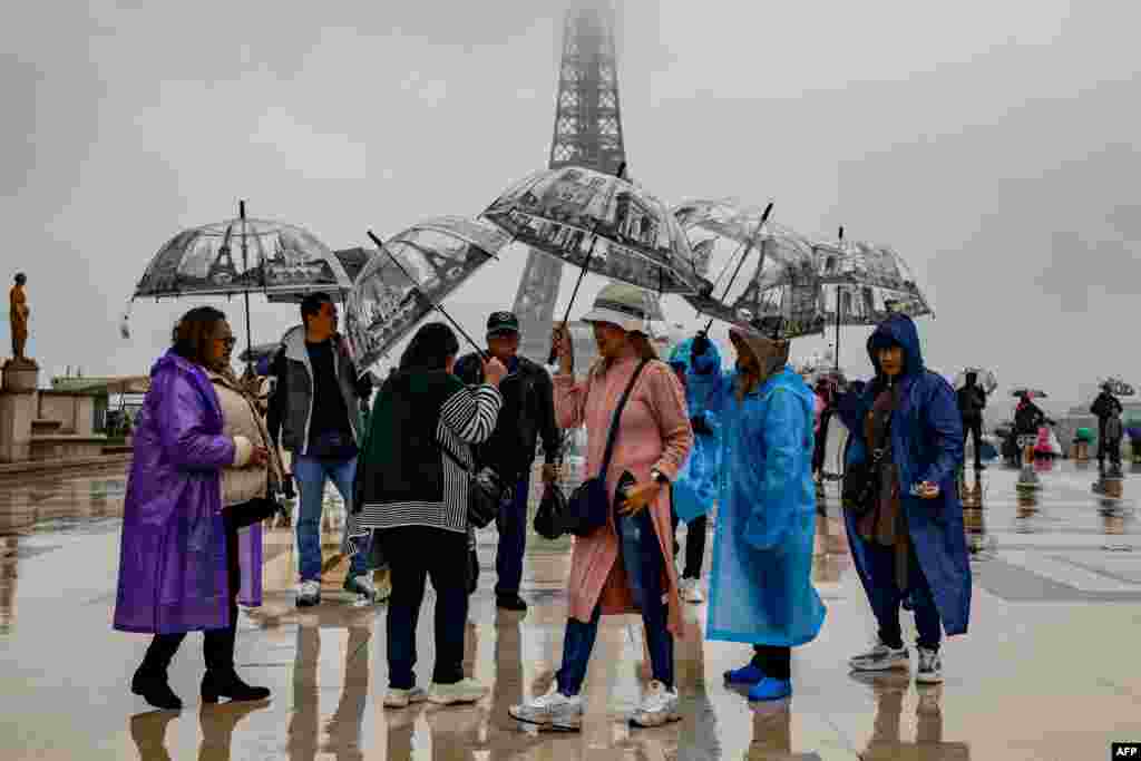 Visitors shelter from the rain with umbrellas on the Parvis des Droits de l&#39;Homme on Esplanade du Tocadero across from the Eiffel Tower, as remnants of hurricane Kirk cause heavy rainfall over Paris, France.