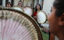 Yazidi muda dan wanita Muslim berlatih lagu tradisional Kurdi diiringi oleh Daf, drum kerangka Kurdi besar, di sebuah pusat komunitas di Dahuk, Irak, pada 25 Juni 2019. (Foto: AFP/Safin Hamed)