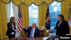 美国总统川普与白宫通讯联络主任希克斯（左）、白宫新闻秘书桑德斯（右）在白宫商讨事情。（2018年1月17日）