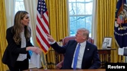  prezidan ameriken an, Donald Trump pandan li tap pale ak konseye li Hope Hicks (L) . Madam Hicks gen 29 van sou tèt li e li se te pi jèn chèf kominikasyon Lamezon Blanch. Washington, Etazini 17 janvye 2018. 