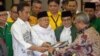 Indonesia's President Joko Widodo, front left, and the head of Indonesian Ulema Council Maruf Amin, center, submit their documents to election commission officials in Jakarta, Aug. 10, 2018, during their registration for the 2019 presidential election as president and vice president candidates.