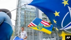 Demonstran pro-Ukraina Thomas Cooney memegang bendera di luar KTT NATO di Washington, Rabu, 10 Juli 2024. (Foto: AP)