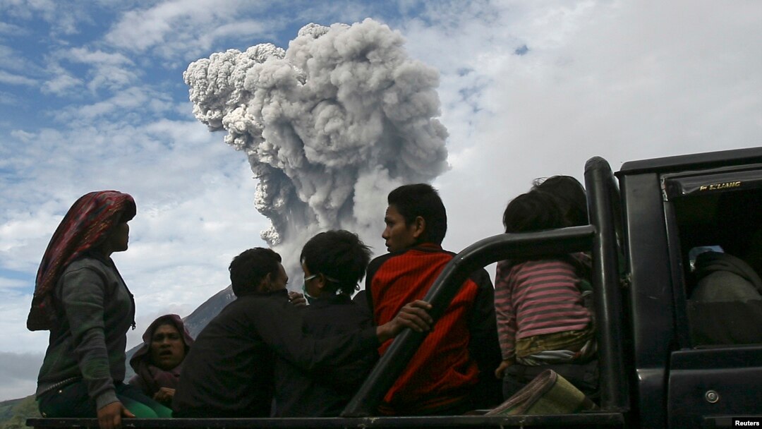 Warga desa duduk di truk saat melakukan evakuasi ke tempat aman, menyusul letusan Gunung Sinabung (24/11) di desa Aman Teran, kabupaten Karo, Sumatera Utara. (Reuters/YT Haryono)