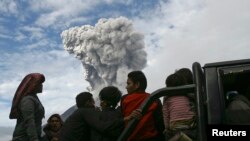 Warga desa Aman Tera, kabupaten Karo dievakuasi dengan truk saat Gunung Sinabung menyemburkan lava November 2013. (Reuters/YT Haryono)