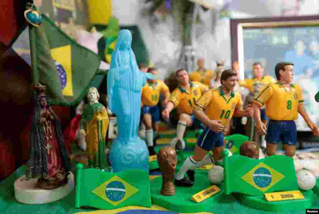 O ditado diz que Deus é brasileiro, Marilza juntou as suas figuras religiosas com os bonequinhos da equipa de futebol, em Brasília, Maio 27, 2014. REUTERS/Joedson Alves