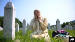 Bosanska muslimanka tuguje pored groba svog rođaka, žrtve genocida u Srebrenici, u Memorijalnom centru u Potočarima u Bosni i Hercegovini, 11. jula 2023. 