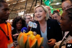 French far-right leader Marine le Pen smiles at the French Caraibean islands stand as she visits the Agriculture Fair, Feb. 28, 2017, in Paris.