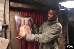 Mathare resident Sarah Wangari looks at photo of her son, gunned down by police in Kenya. (Photo: Rael Ombuor / VOA)