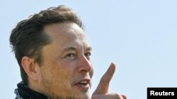 ARCHIVO - El magnate Elon Musk gesticula mientras visita la construcción de una fábrica de Tesla cerca de Berlin, Alemania, el 13 de agosto de 2021.