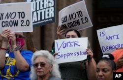 FILE - Demonstrators join a rally to protest proposed voting bills on the steps of the Texas Capitol, July 13, 2021, in Austin, Texas.