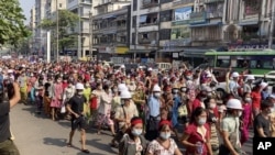 En esta imagen tomada de un video, una multitud de manifestantes marchan por Rangún, Birmania, el 6 de febrero de 2021.